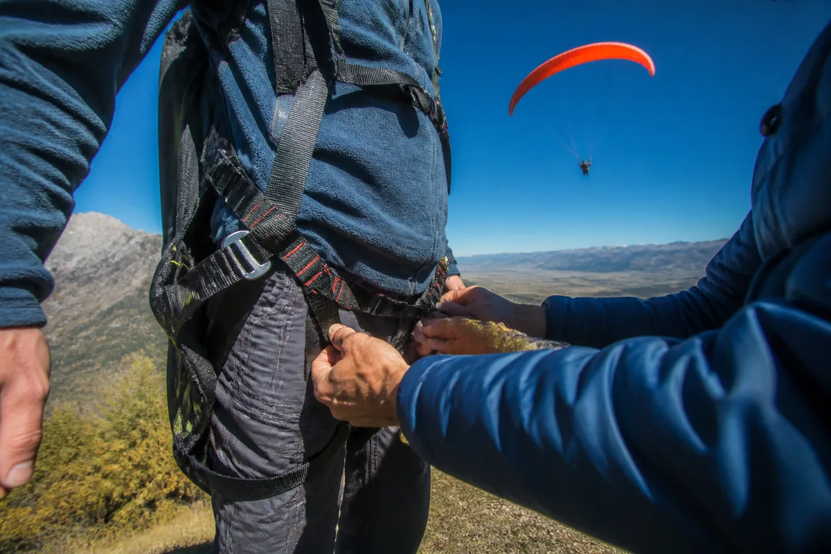 Sangles de harnais tandem ajustées sur un pratiquant au sol