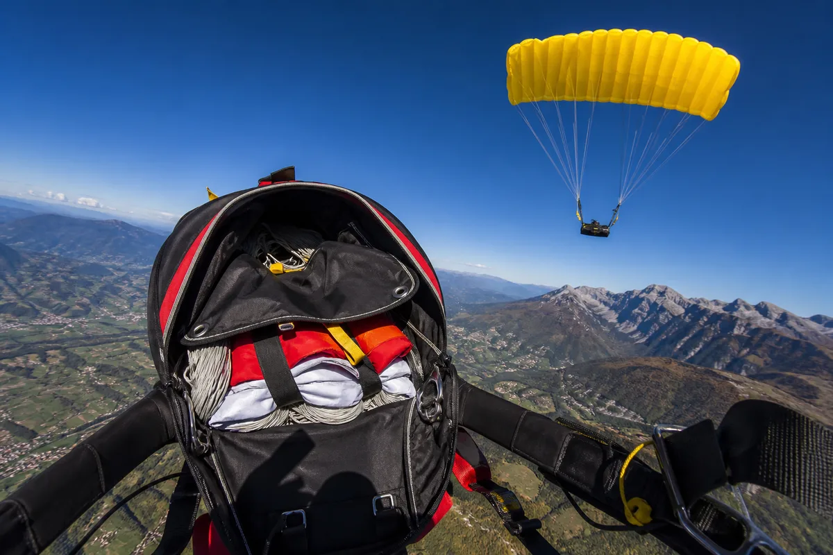 Sac-harnais de parachutisme ouvert montrant ses compartiments et ses sangles